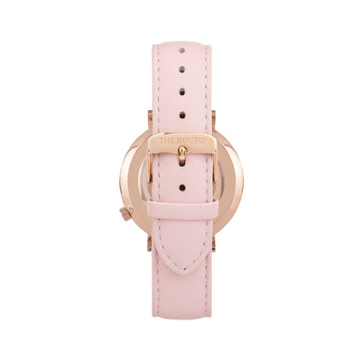 Rose gold and white watch with a stitched blush pink genuine leather band and rose gold black buckle designed by THE HOUND, styled done up and shot from behind.