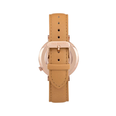 Rose gold and white watch with a stitched camel genuine leather band and rose gold black buckle designed by THE HOUND, styled done up and shot from behind.