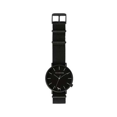 Matte black and black watch with a soft black nato band and matte black buckle designed by THE HOUND, styled flat and shot from above.